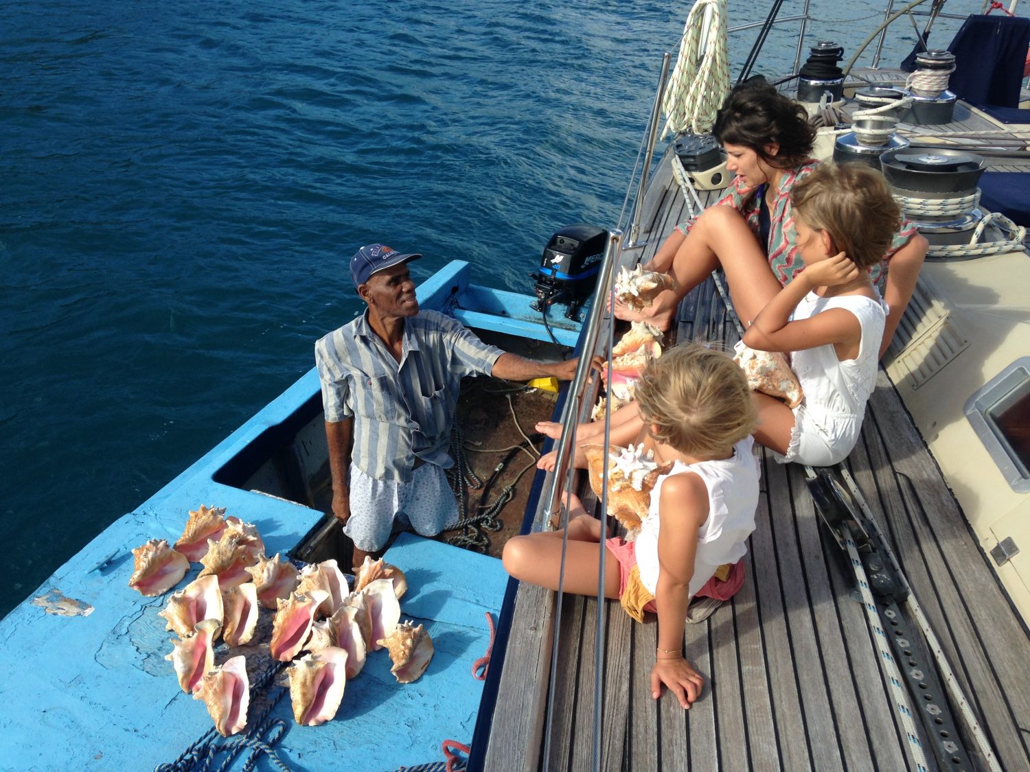 Family choosing conch shells on a BVI Crewed Yacht Charter onboard SY Pacific Wave