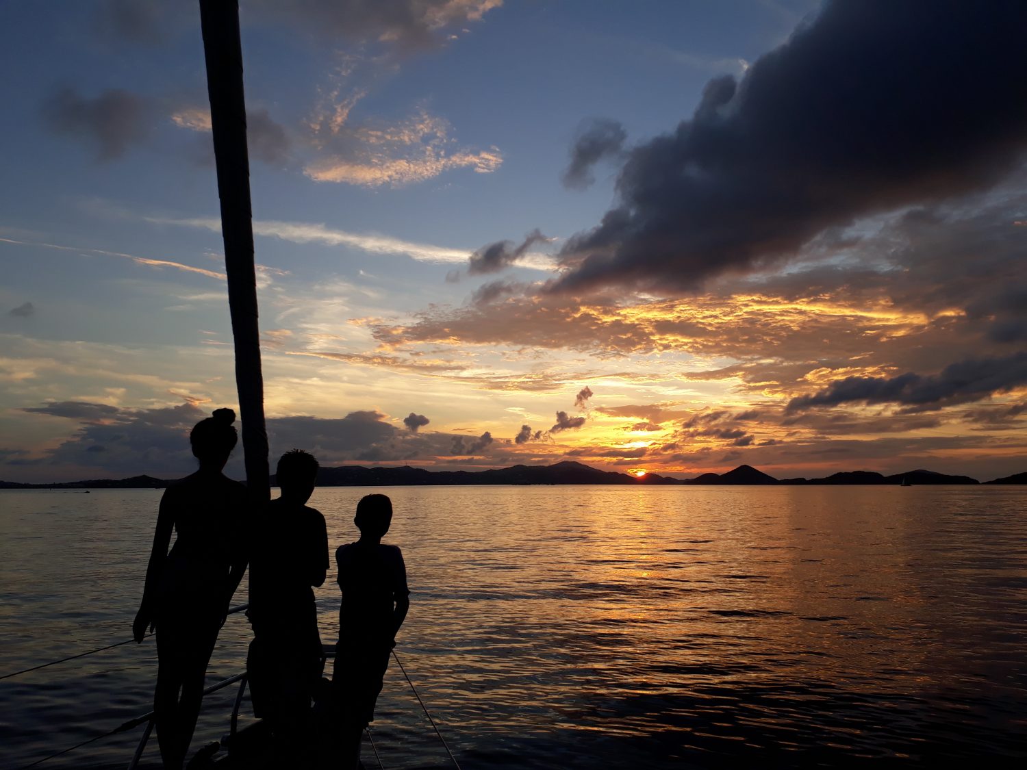 Family onboard Pacific Wave watching the sunset on a BVI Crewed Yacht Charter